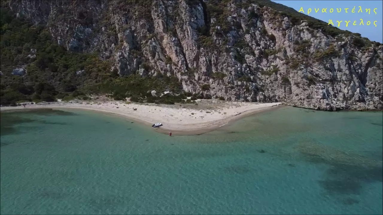 Μια μικρή λωρίδα ήσυχης αμμουδερής ακτής κάτω από απειλητικά βράχια κοντά στην Πύλο